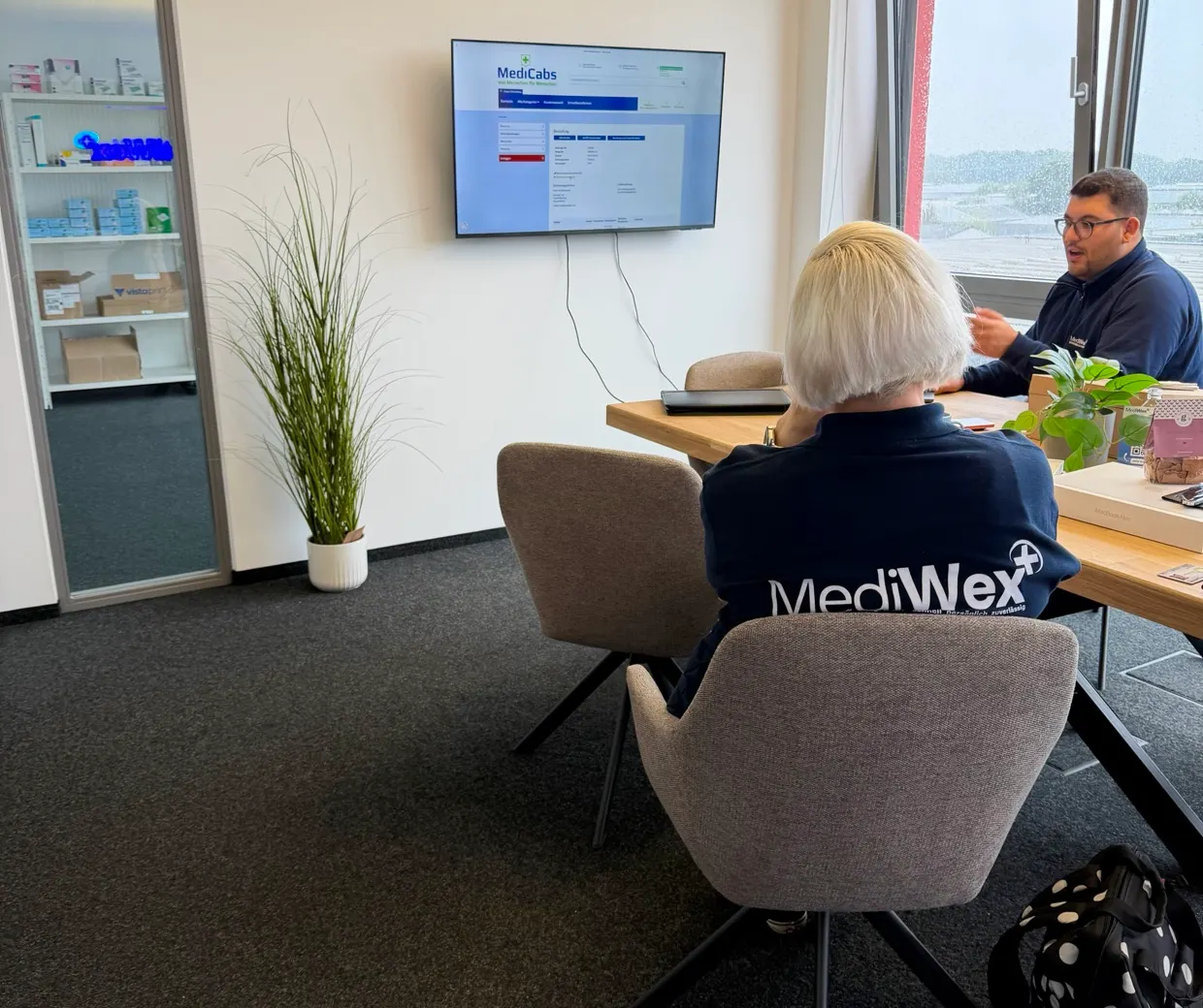 Zwei Teammitglieder von Mediwex besprechen eine Dokumentation am Tisch